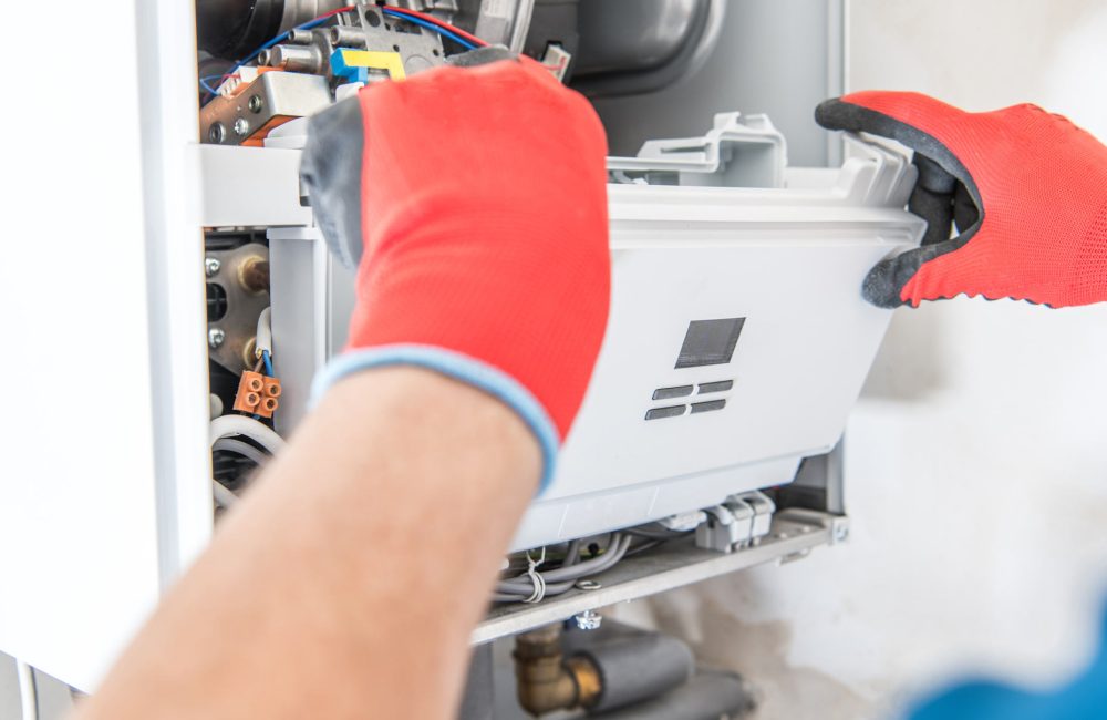 Technician’s hands removing furnace component for repair – Shift Heating and Cooling Services Calgary