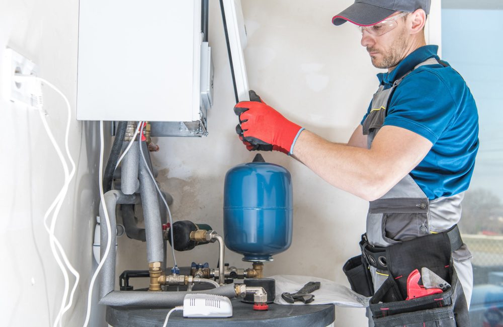Technician servicing residential boiler system with expansion tank – Shift Heating and Cooling Services Calgary HVAC