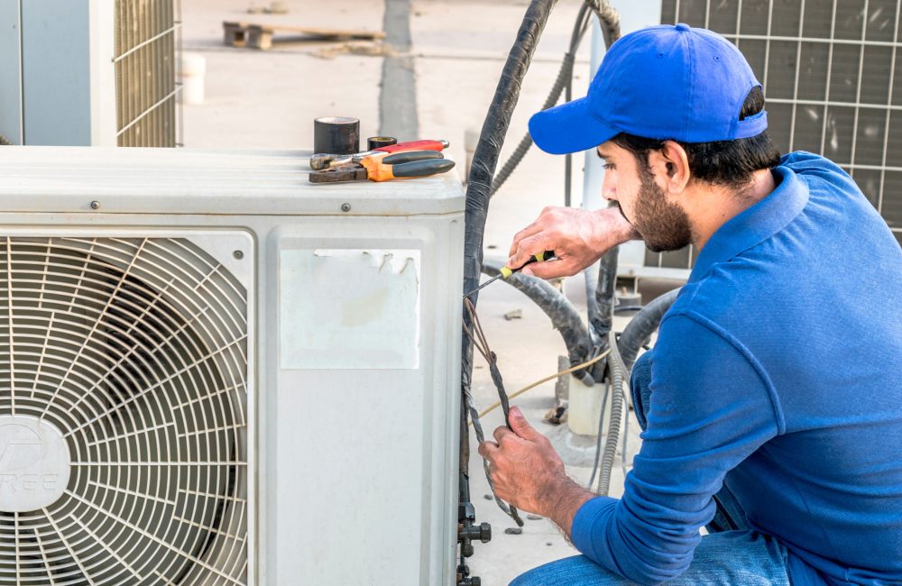 Calgary HVAC technician repairing outdoor air conditioner – Shift Heating and Cooling Services