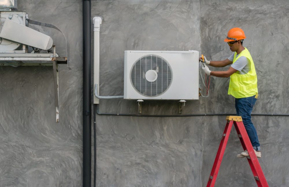 Calgary HVAC technician installing an outdoor split air conditioning unit on home exterior – expert AC installation by Shift Heating and Cooling Services