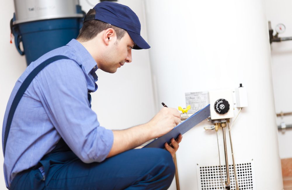 Technician inspecting a hot water heater in Calgary home – Shift Heating and Cooling Services